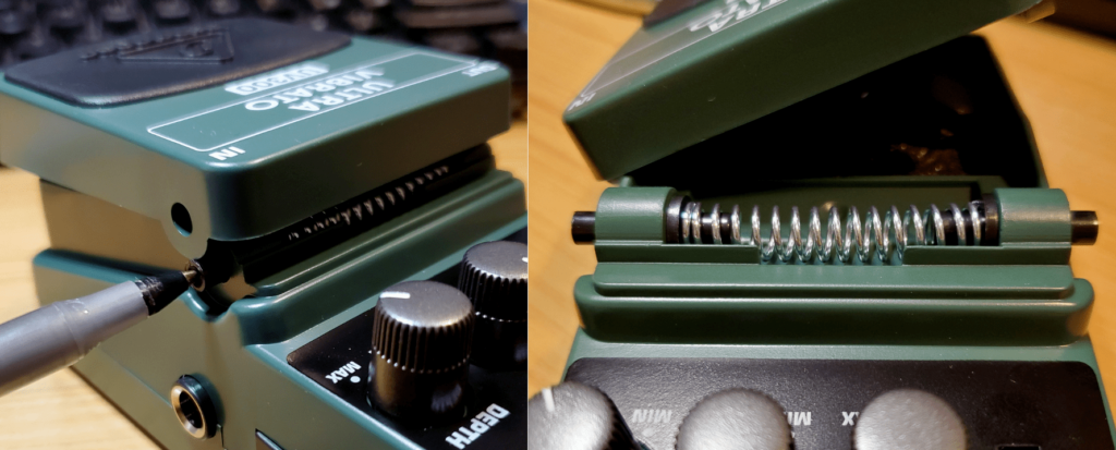 Using a pen to remove the battery cover from a Behringer pedal.