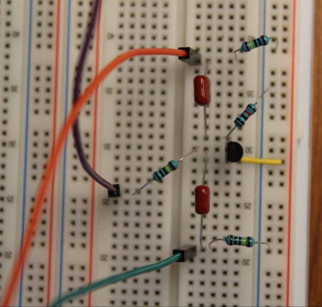 Transistor Buffer breadboarded on the PROTIS 1. The orange wire connects to the output pin, the purple wire connects to the reference voltage pin, and the green wire connects to the input pin.